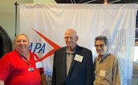 three men standing in front of a banner