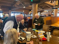 a group of people standing around a table