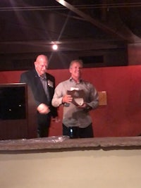 two men standing next to each other at a podium