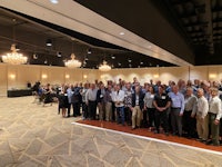 a group of people posing for a picture in a large room