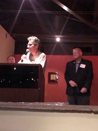 a man is standing at a podium and giving a speech