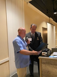 two men standing in front of a podium with a microphone