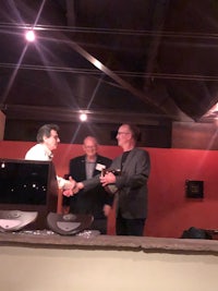 two men shaking hands at a podium