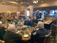 a group of people sitting around a table in a restaurant